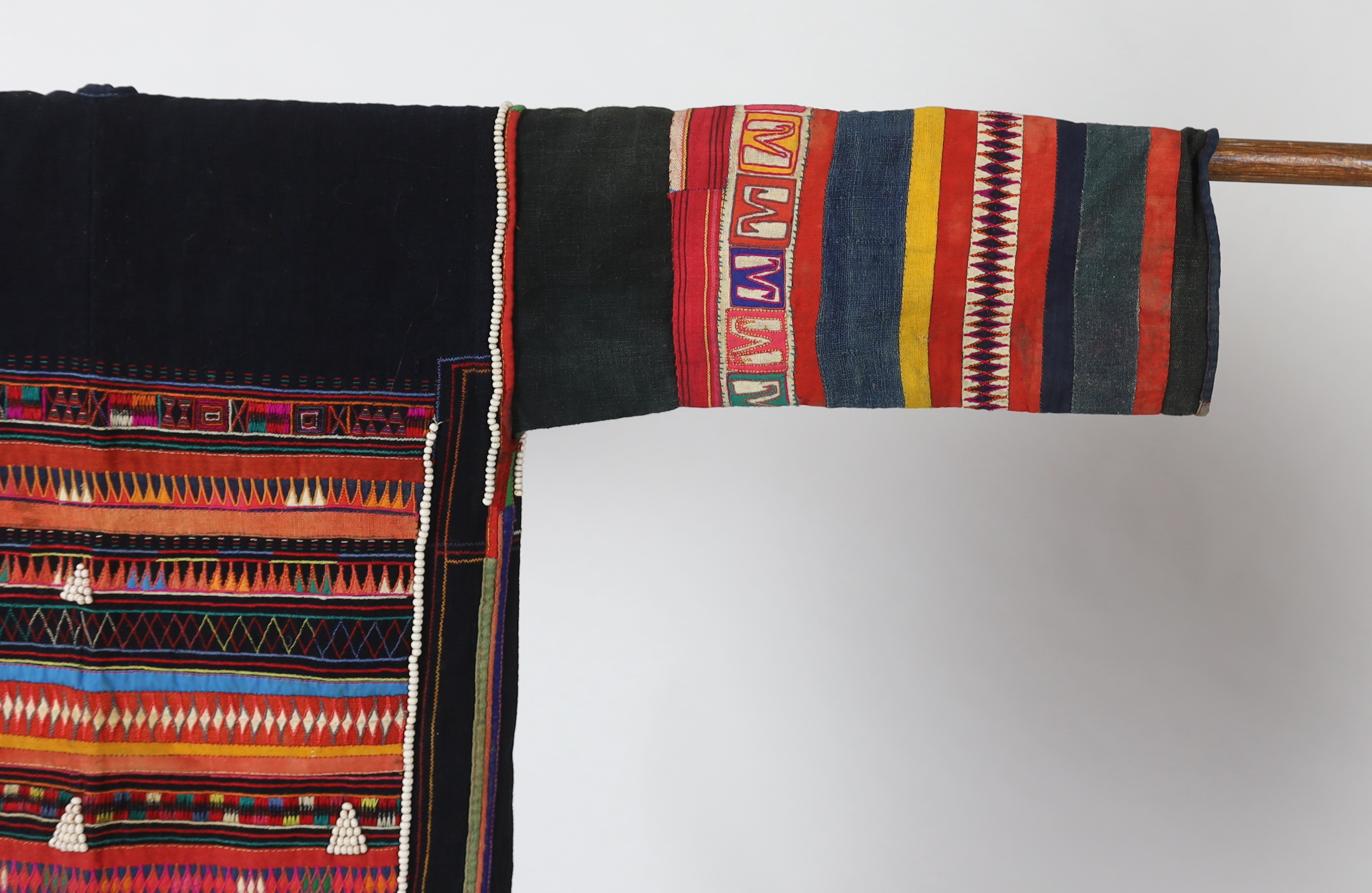 A Chiang Mai (Thailand) embroidered ladies three quarter length jacket, embroidered in hand dyed polychrome threads, (HKHA jacket) with beaded borders and spot design on a hand woven linen, 79cm long from neck to base